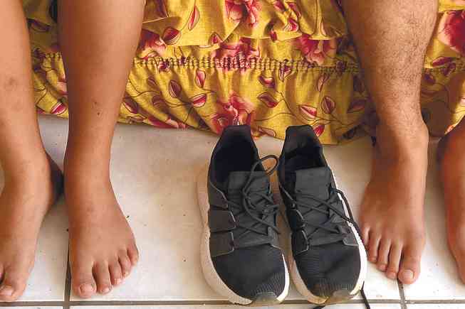FORÇA COMPARTILHADA – Os pés dos meninos de 11 e 15 anos, que precisam percorrer seis quilômetros diariamente, dividem o mesmo calçado