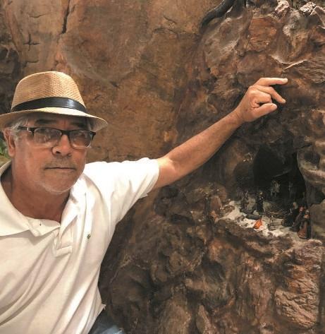 O artista Antônio Edgar ao lado do presépio feito em rocha que preservou dentro da sala de casa (MANOEL FREITAS)
